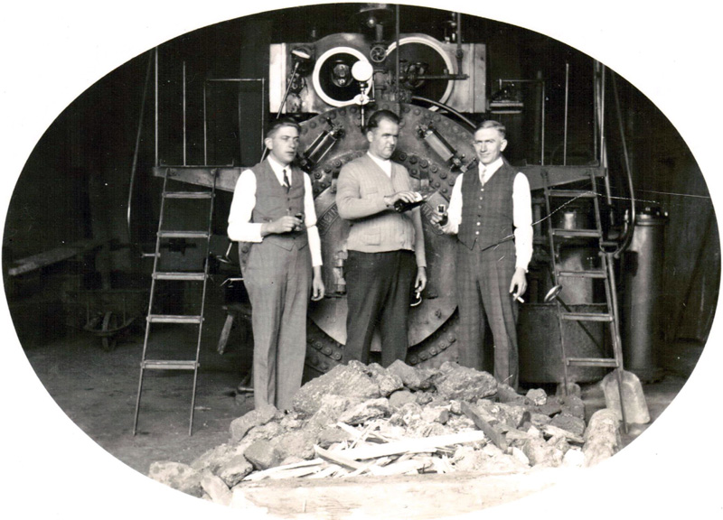 Die Herren Wimmers, Junkers und Hüsen 1923 vor dem Doppelzylinder-Lokomobil, mit dessen Hilfe Maschinen angetrieben wurden (StA Kaarst D3-3 Nr. 318)