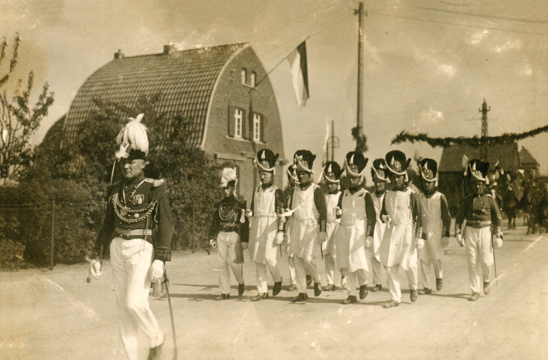 Kaarst, Maubisstraße; Ein Pioniercorps beim Schützenfest Anfang der 1930er Jahre vor dem Haus mit dem markanten Zollingerdach (StA Kaarst D3-3-99).