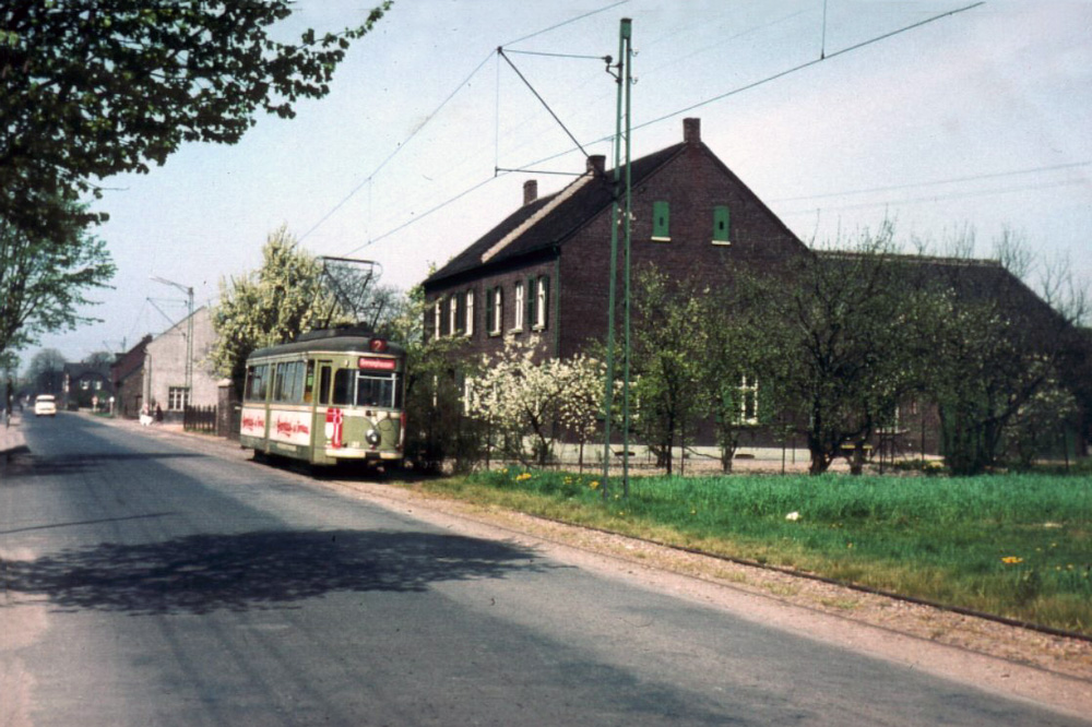 Kaarst, Neusser Straße, Die Straßenbahn im Mai 1958 auf der Höhe der Haltestelle Jägerhof (weißes Haus). Man wartete im Übrigen auf der gegenüberliegenden Seite. Durch die Wiese führt heute die Windmühlenstraße.